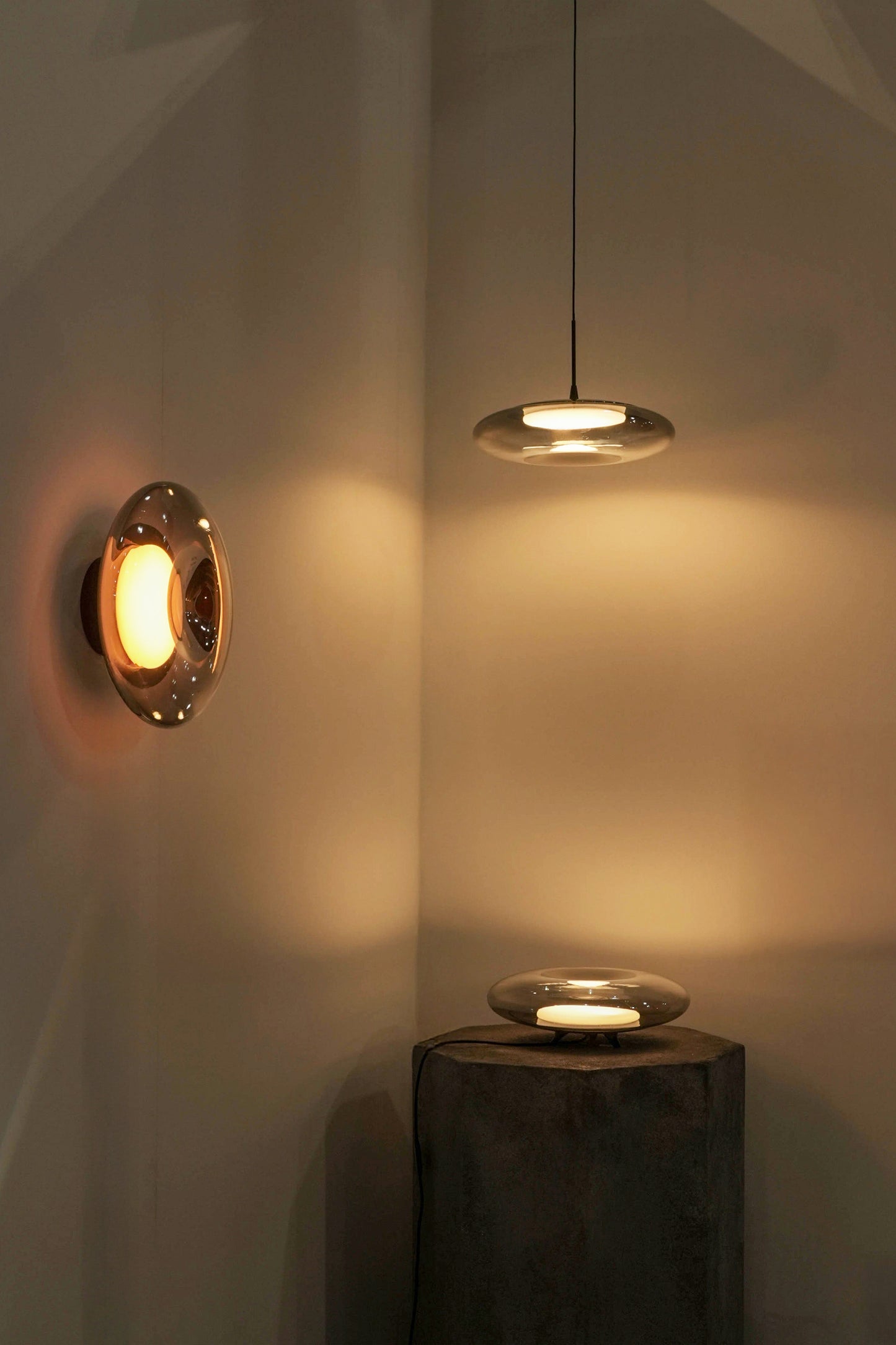 Modern wall and ceiling lights casting warm glow on a neutral wall.