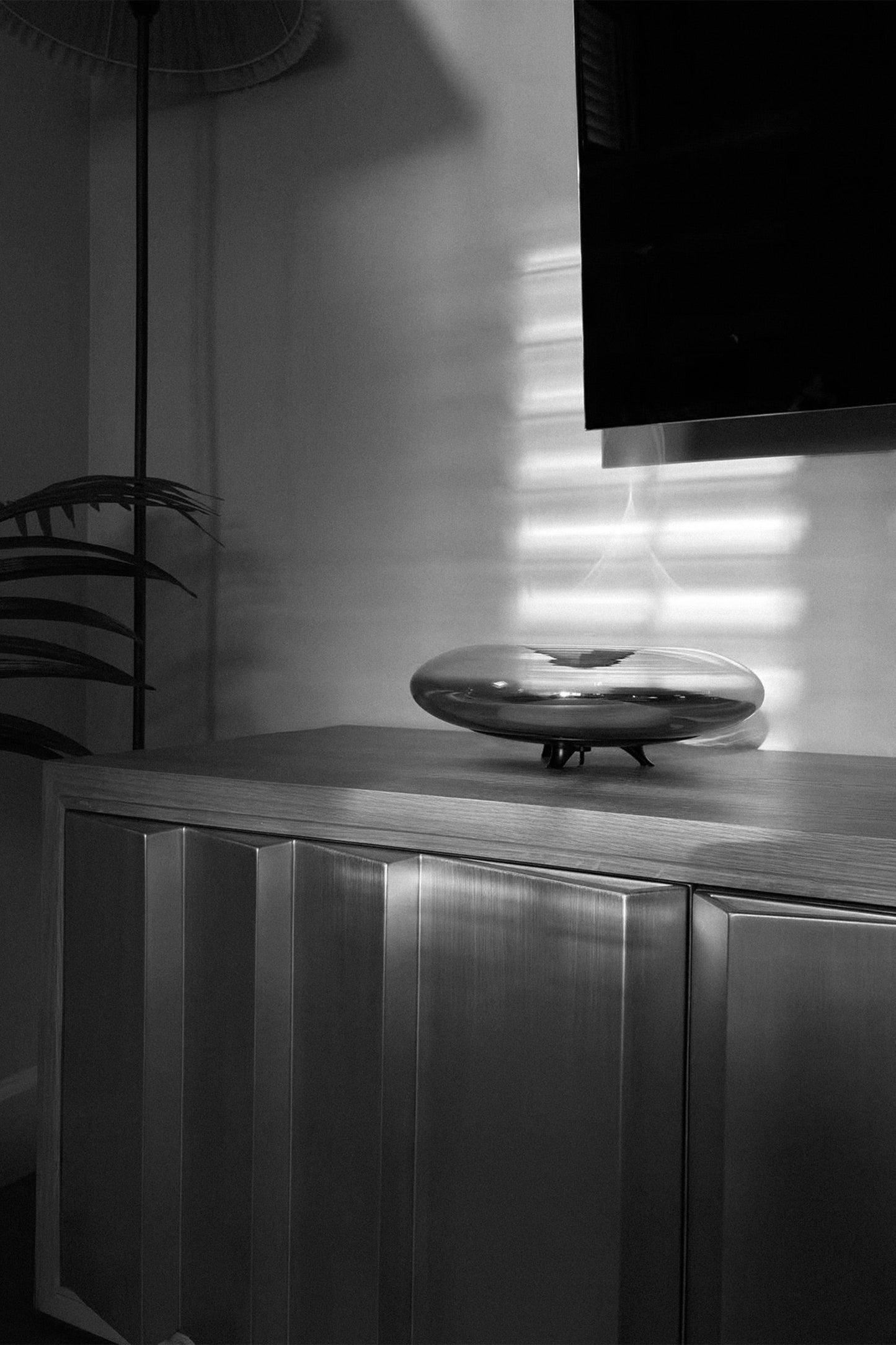 Modern interior with a metallic cabinet and decorative object on a shelf.