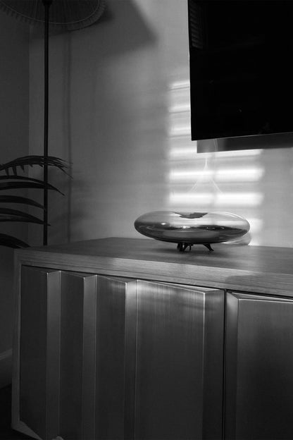 Modern interior with a metallic cabinet and decorative object on a shelf.