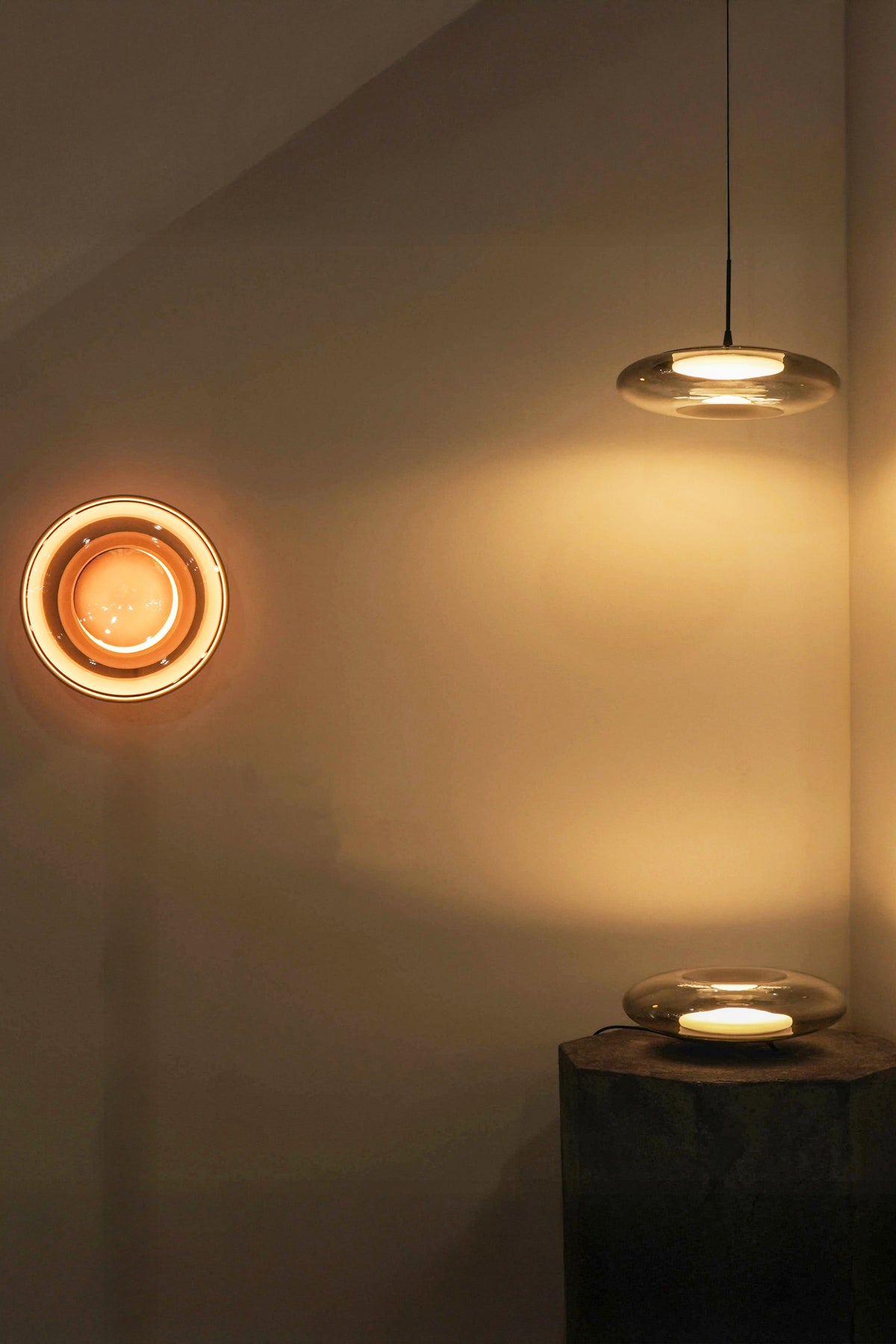 Two round light fixtures on a wall with a warm glow.