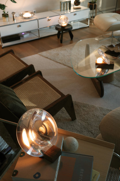 Modern living room with a glass coffee table and decorative lamps.