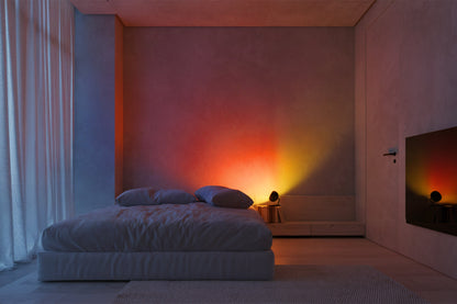 Modern bedroom with a bed and a wall with colorful lighting
