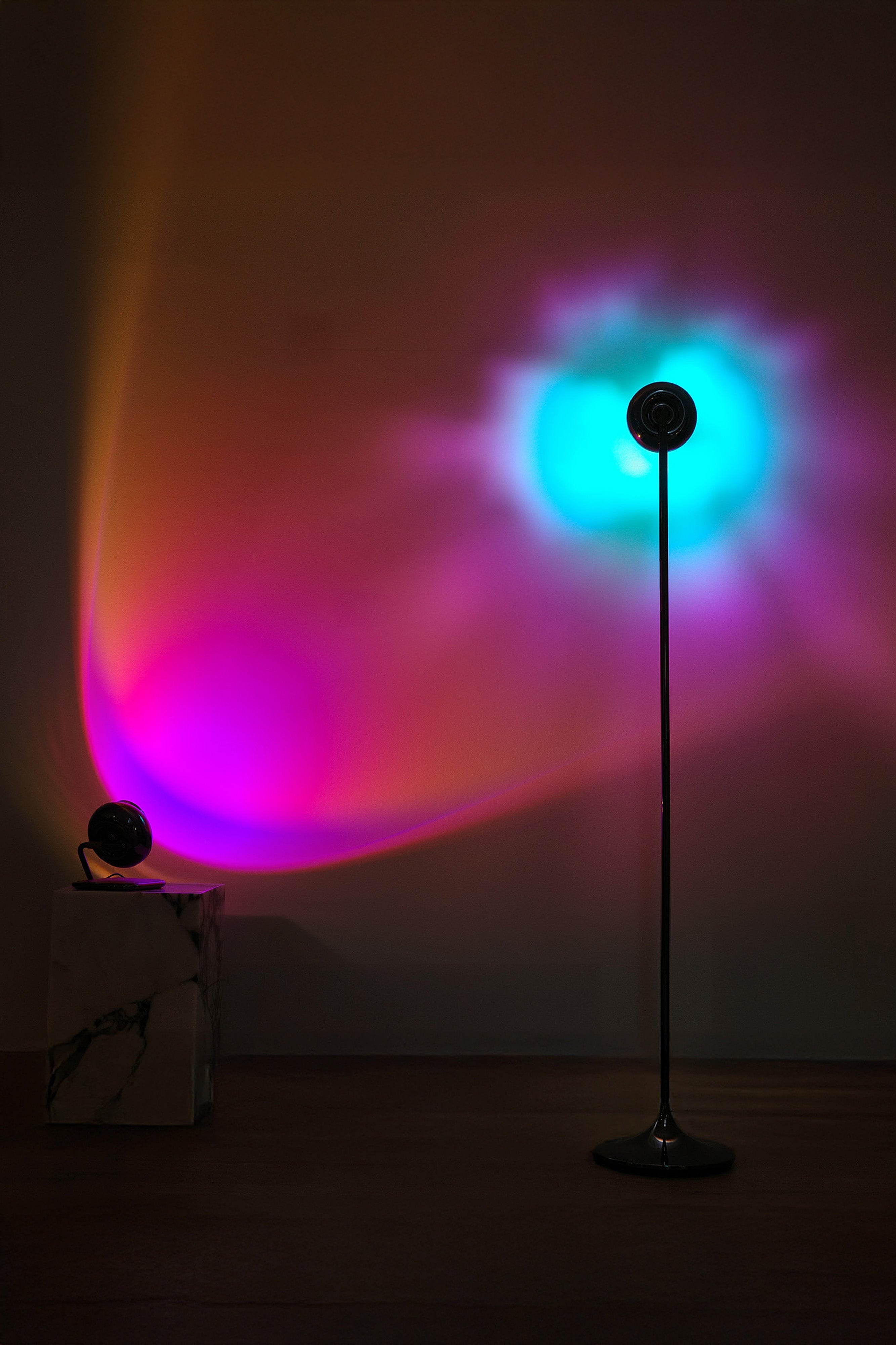 A portable table lamp with a black spherical body and a rotating base, displayed against a neutral background.