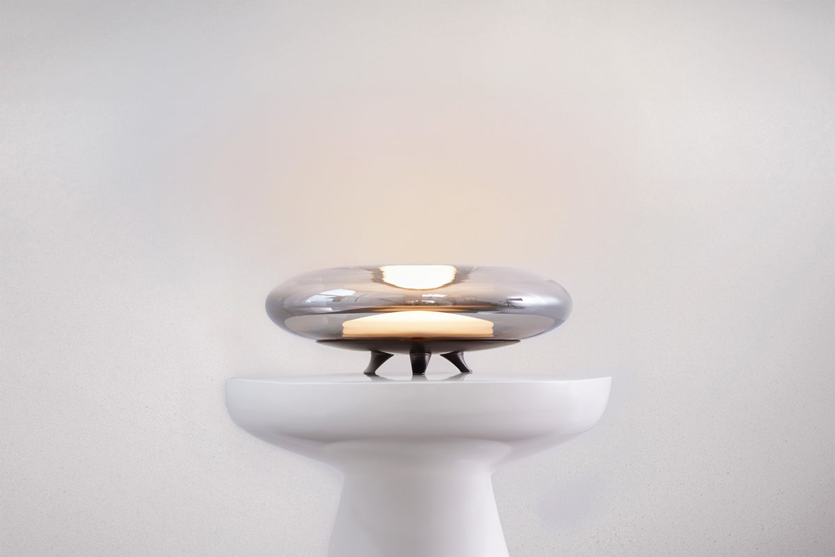 Modern wall light fixture with chrome finish on a white background