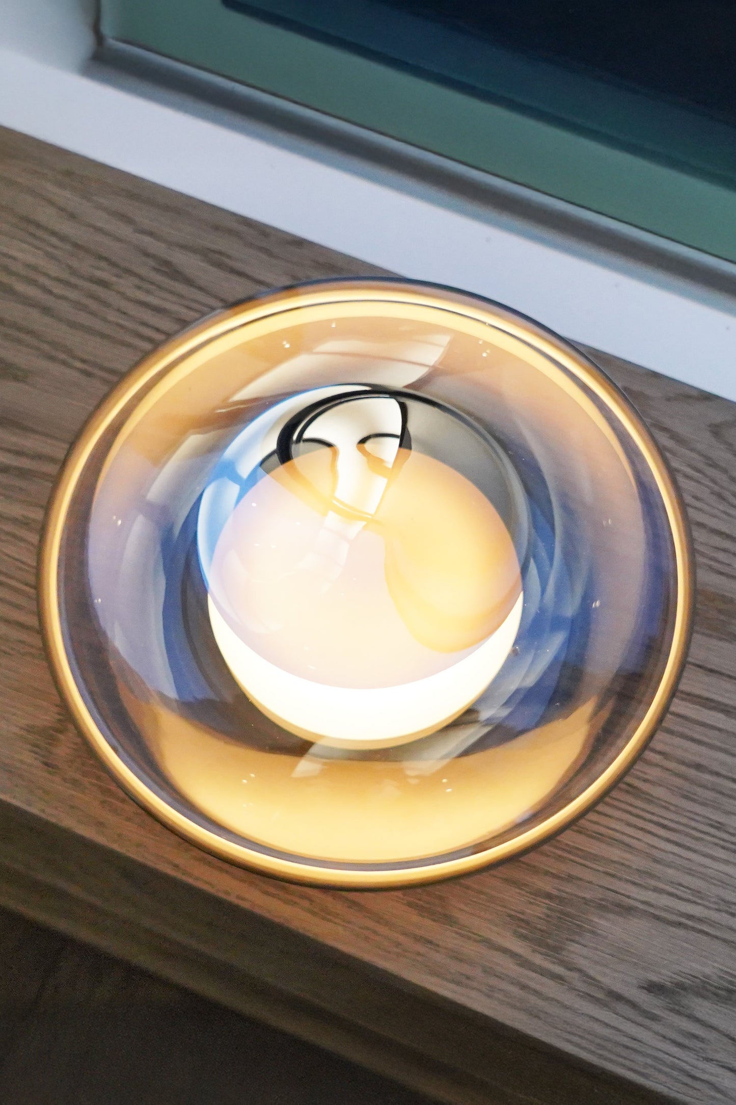 Small round light fixture on a wooden surface