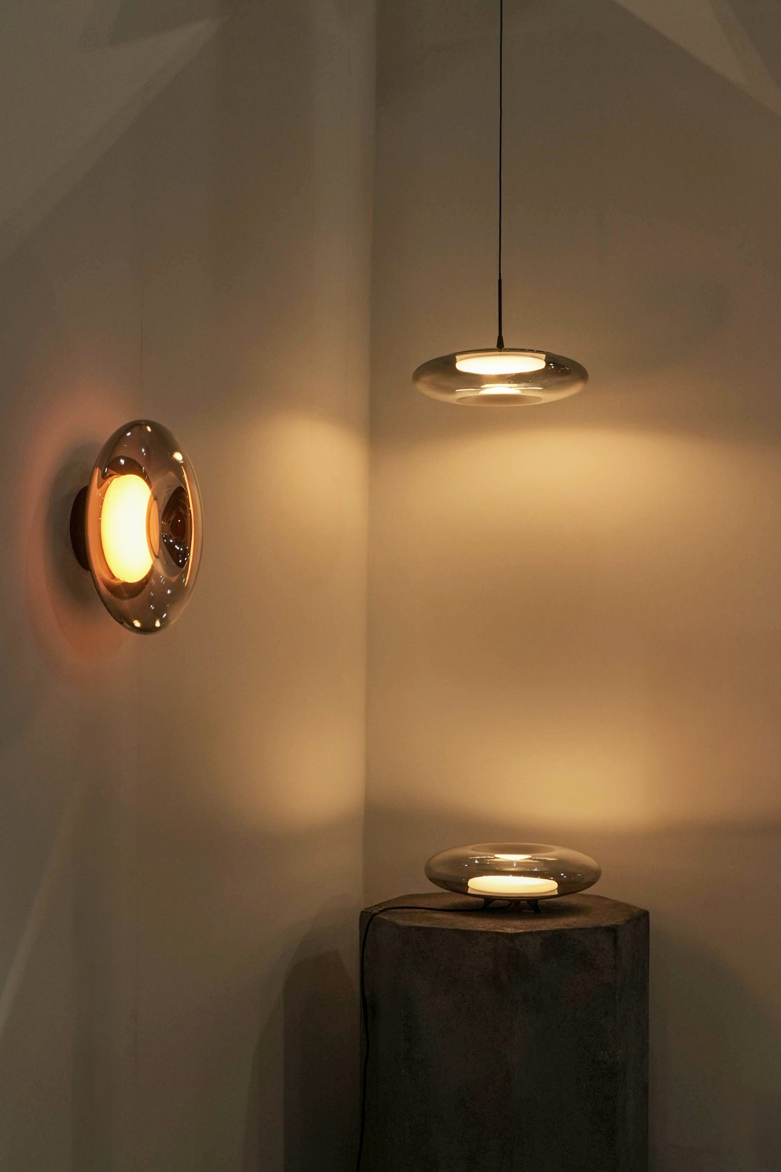 Modern wall and ceiling lights casting warm glow on a neutral wall.