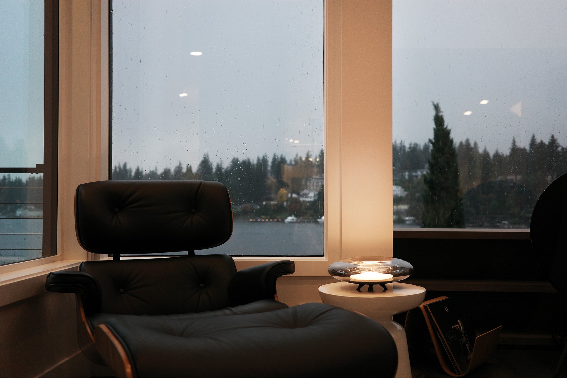 Modern chair by a window with a view of trees and water