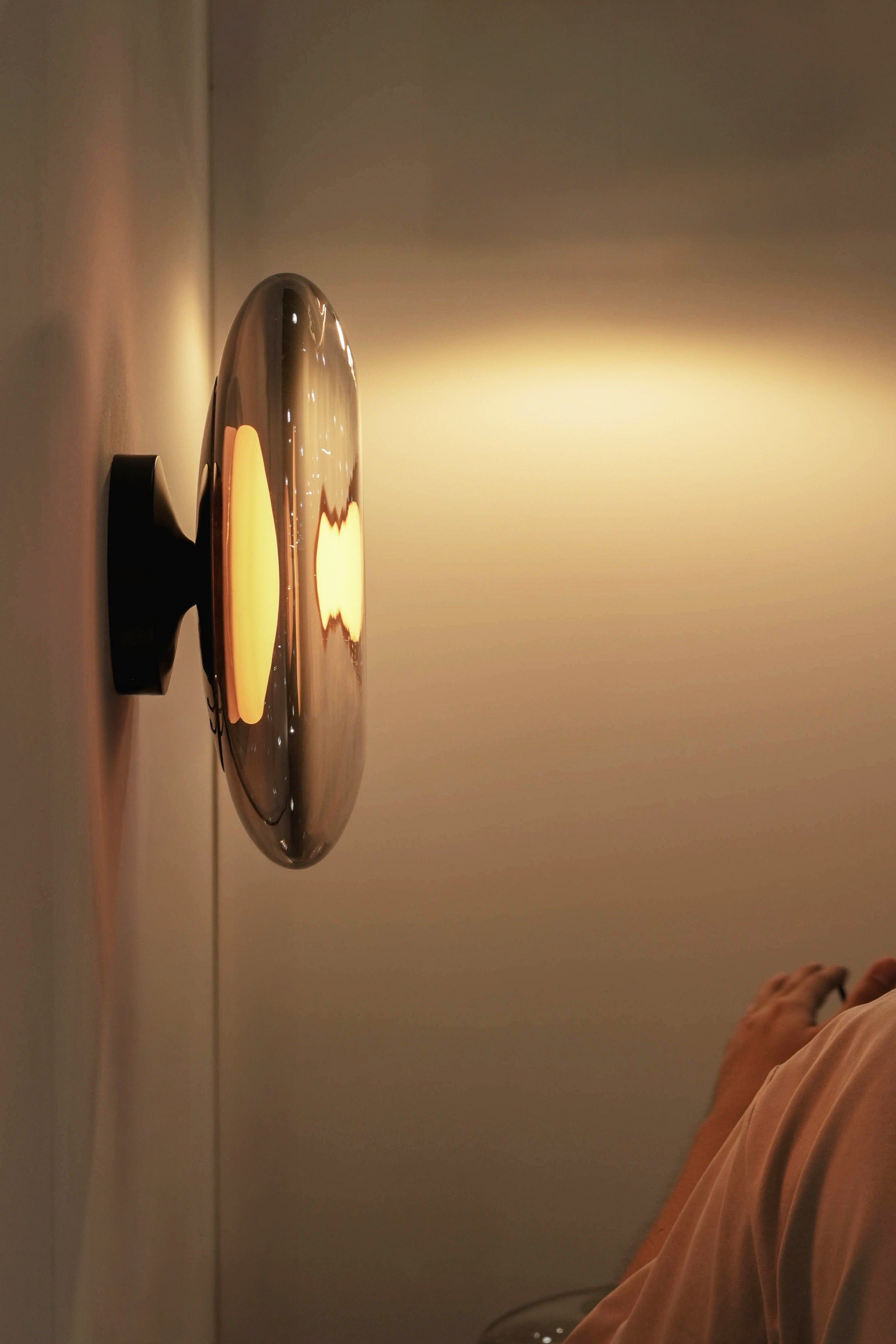 Wall-mounted light fixture casting a warm glow on a wall.