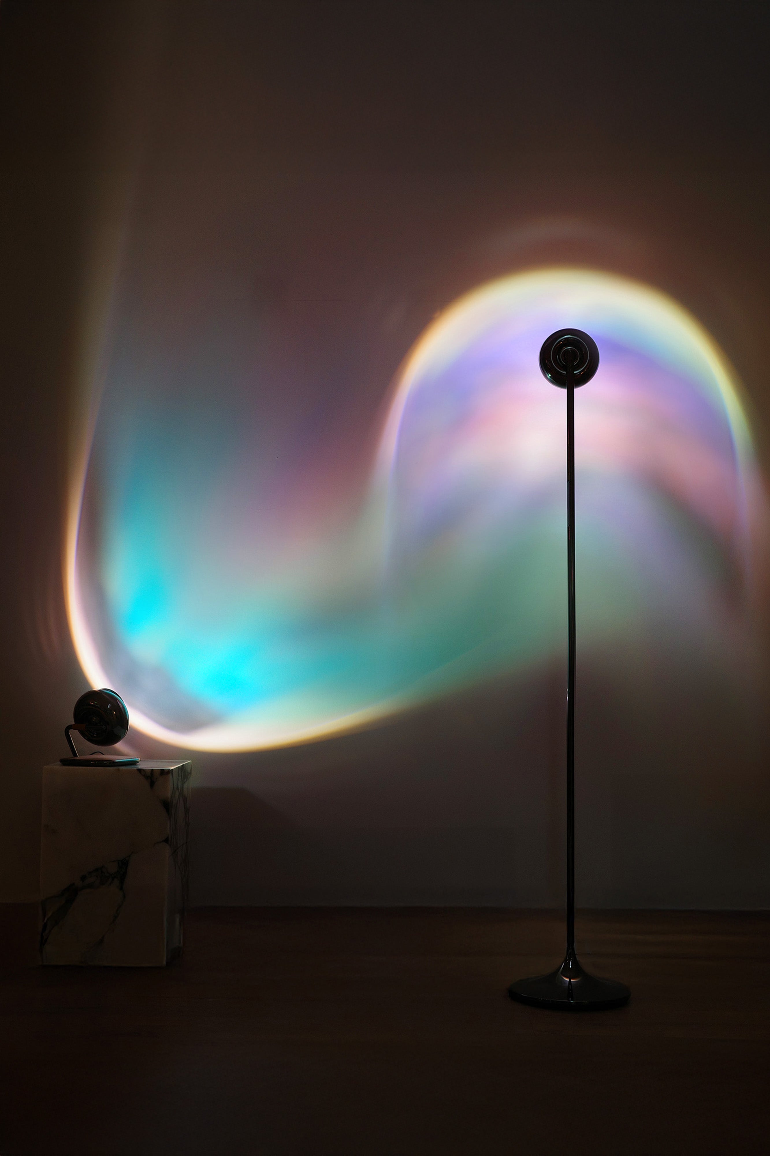 A portable table lamp with a black spherical body and a rotating base, displayed against a neutral background.