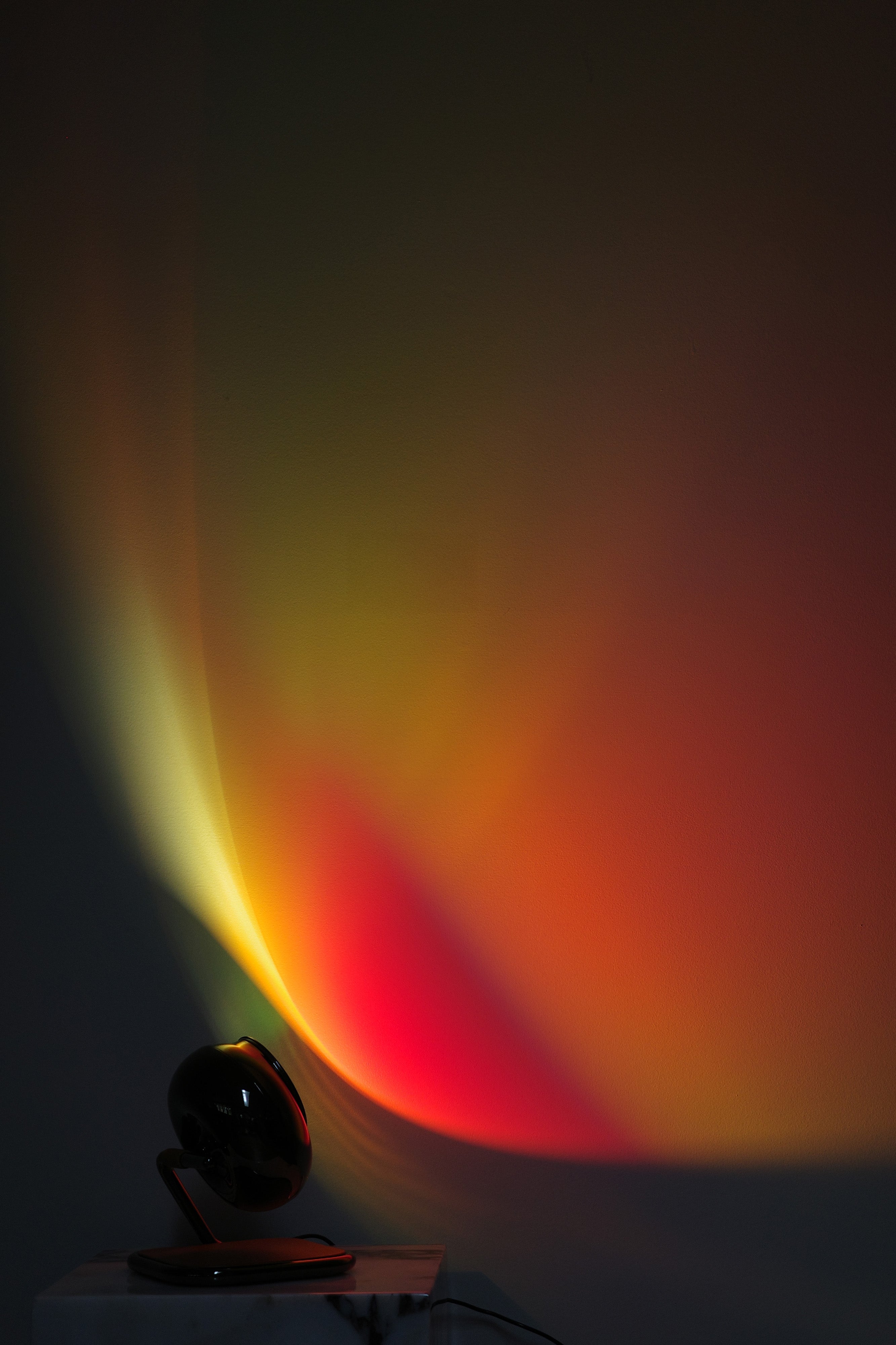Light projector casting colorful beams on a dark wall